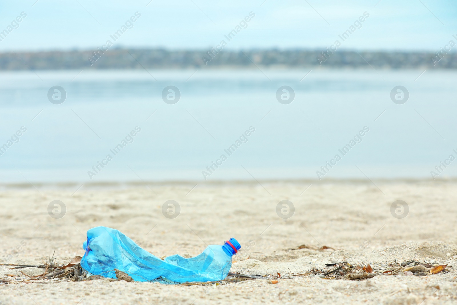 Photo of Used plastic bottle on beach, space for text. Recycling problem