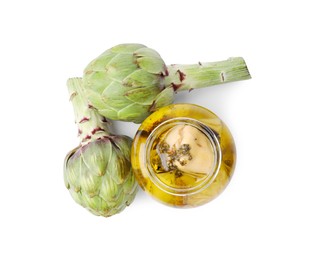 Open jar of delicious artichokes pickled in olive oil and fresh vegetables on white background, top view