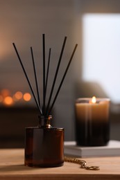 Photo of Reed diffuser on wooden table indoors. Cozy atmosphere