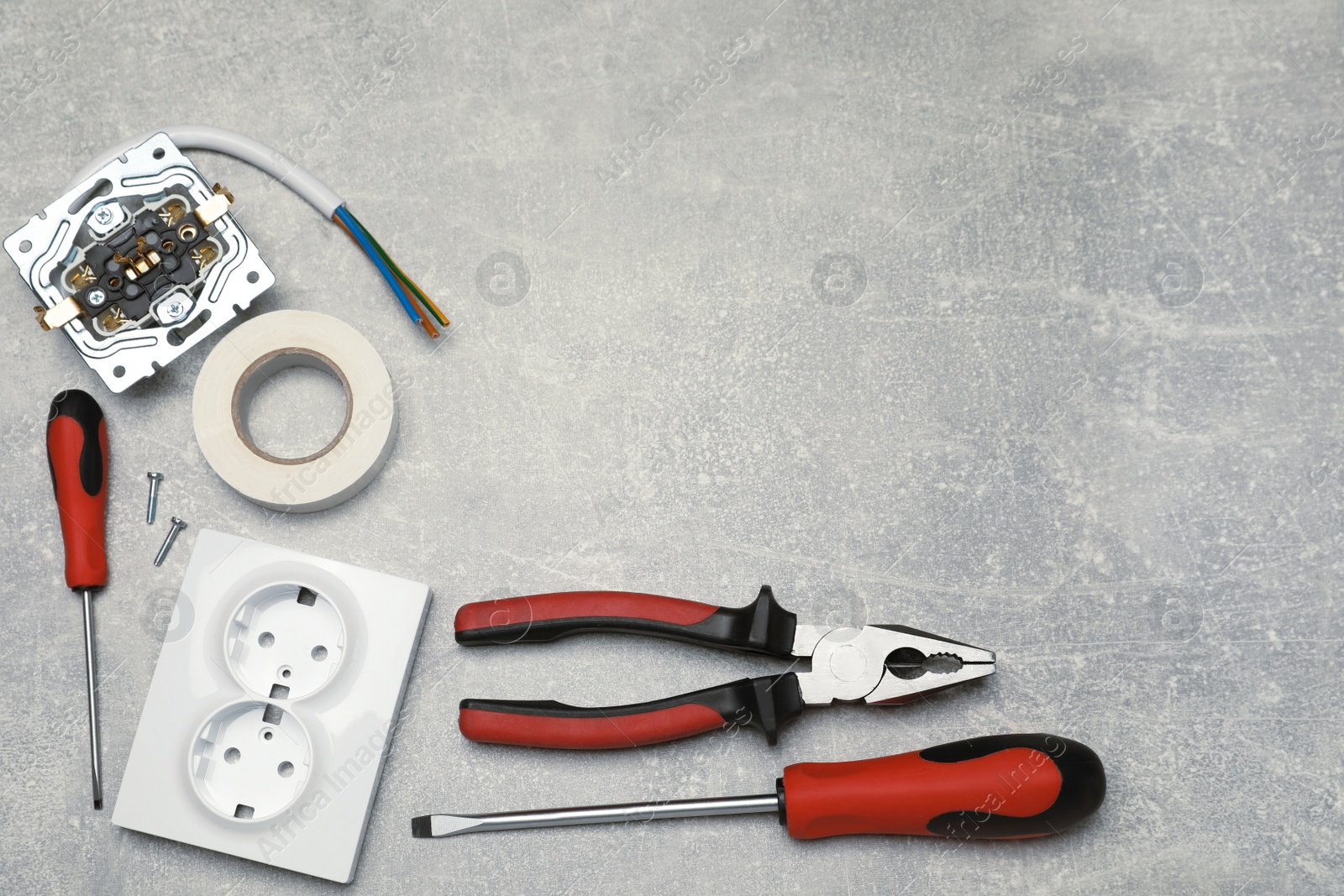 Photo of Power socket and set of electrician's tools on grey table, flat lay. Space for text