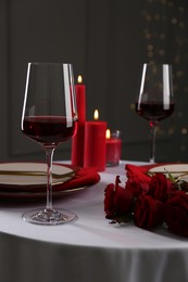 Photo of Place setting with roses and candles on white table. Romantic dinner