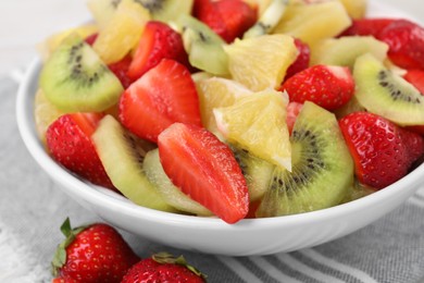 Photo of Delicious fresh fruit salad in bowl on table, closeup