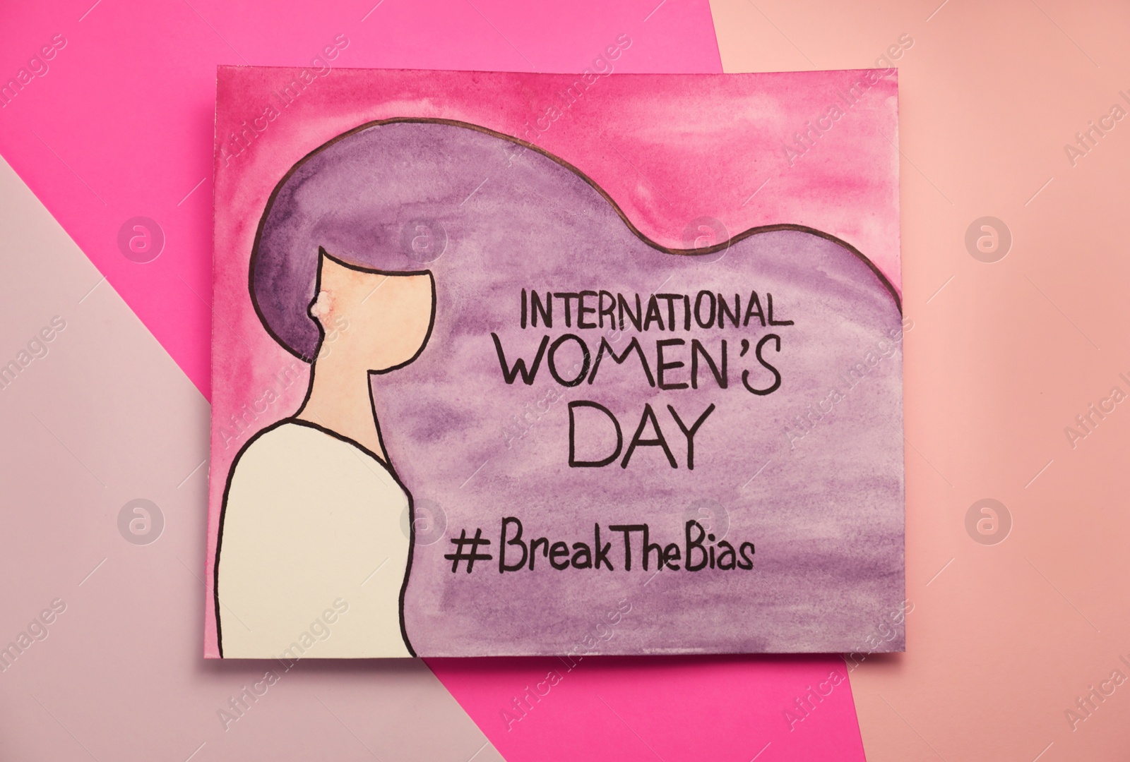 Photo of Card with text International Women's Day, hashtag BreakTheBias and painting of girl on color background, top view