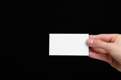 Photo of Woman holding blank business card on black background, closeup. Space for text