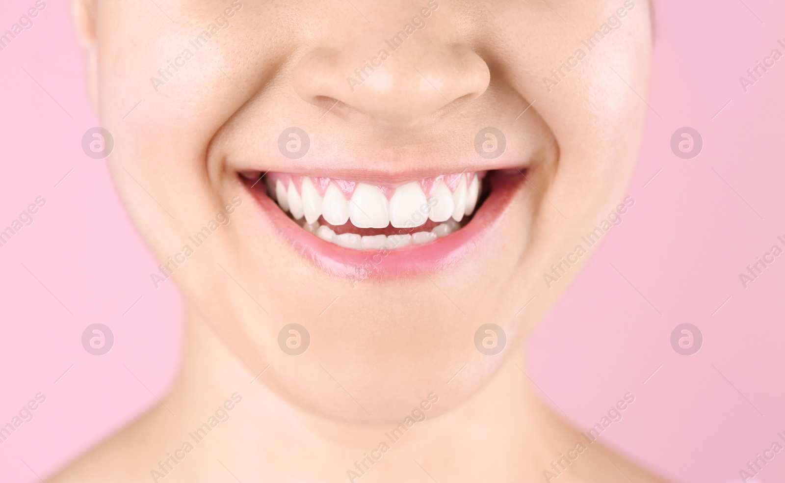 Photo of Young woman with beautiful smile on color background, closeup