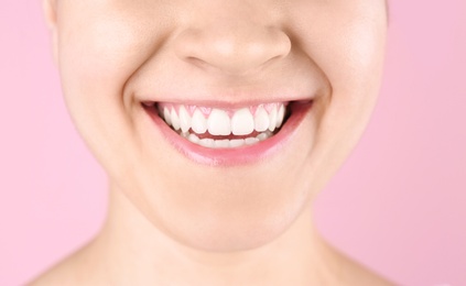 Photo of Young woman with beautiful smile on color background, closeup