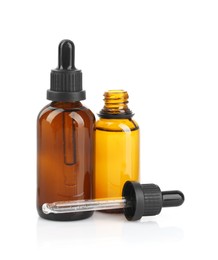 Photo of Glass bottles and pipette with tincture isolated on white