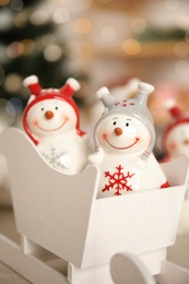 Cute decorative snowmen against blurred background, closeup