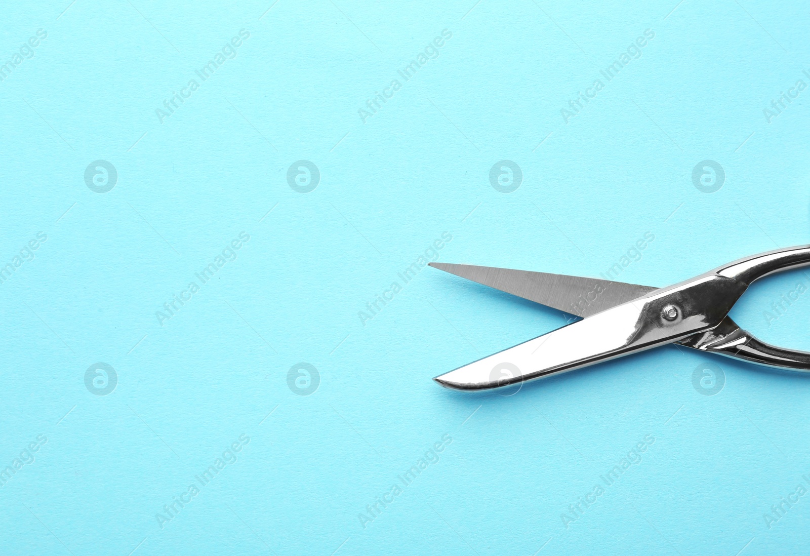 Photo of Pair of sharp scissors on color background, top view. Space for text