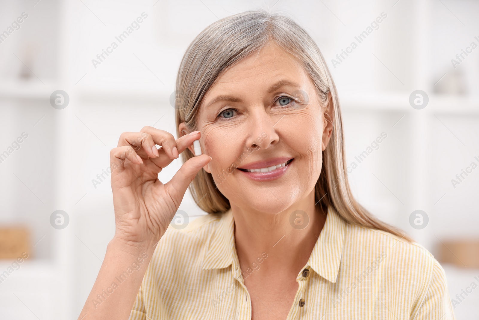 Photo of Menopause, hormone replacement therapy. Happy woman holding pill at home