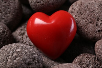 Photo of One red decorative heart on stones, closeup