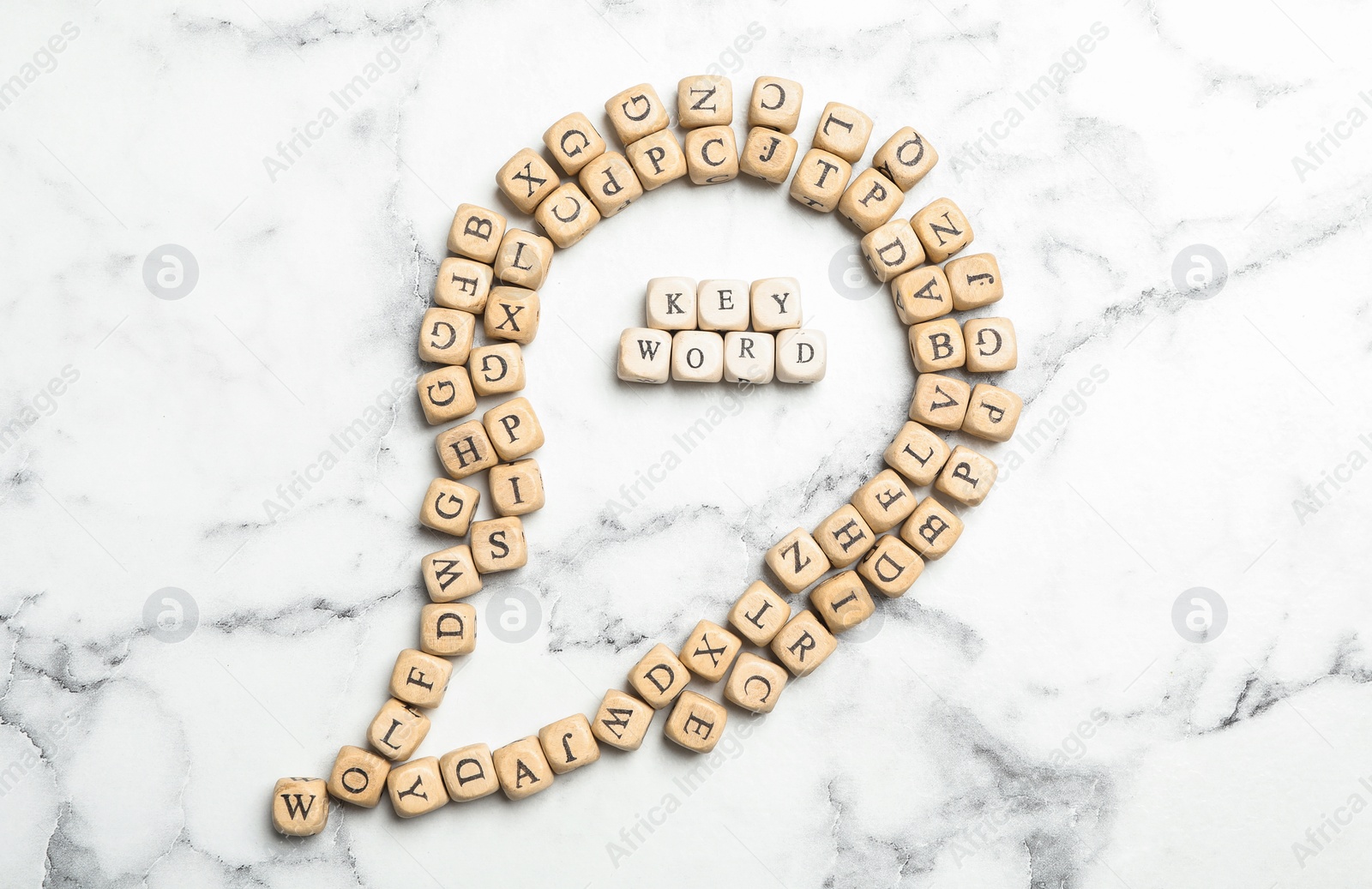 Photo of Beads with word KEYWORD on white marble background, flat lay