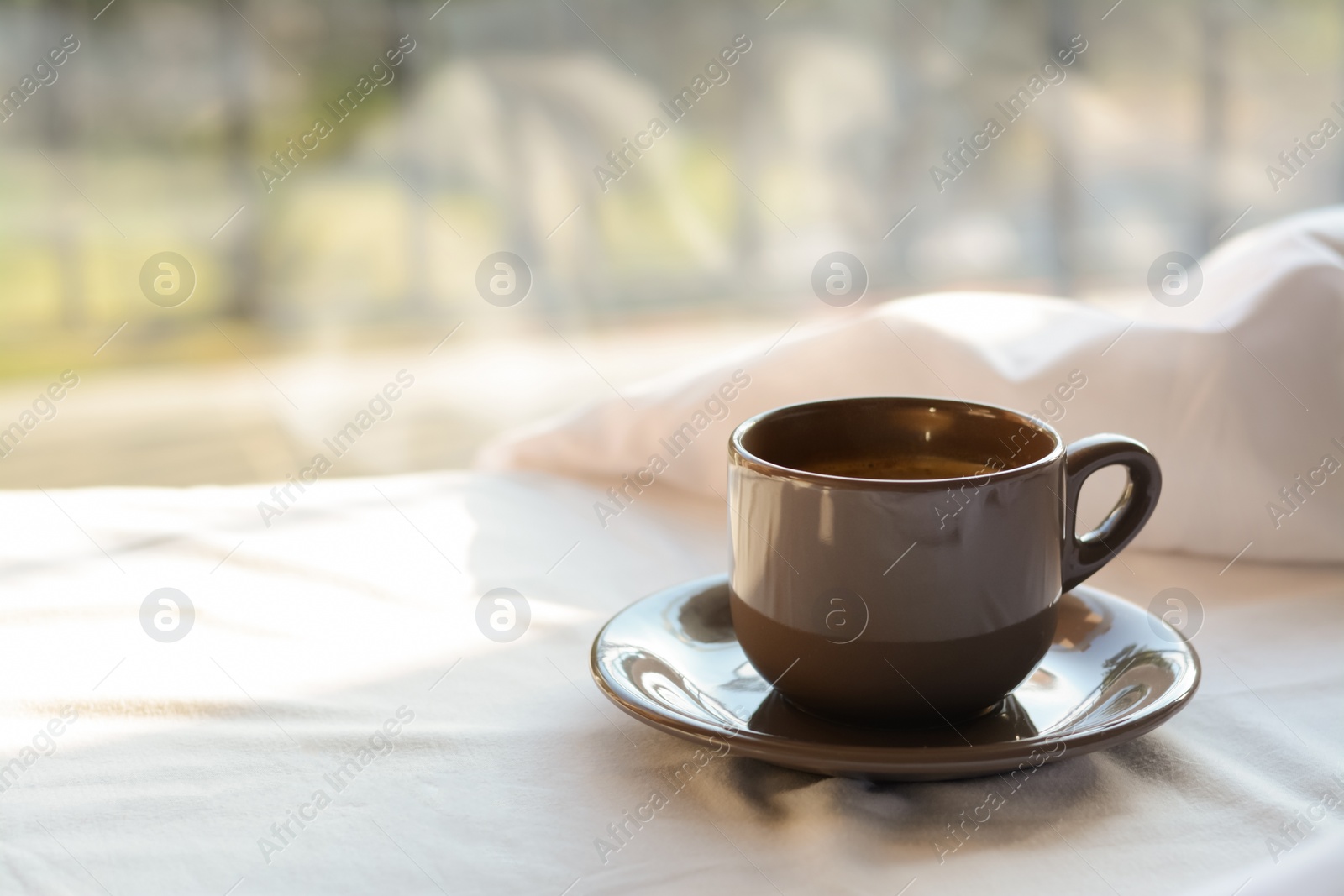 Photo of Aromatic morning coffee on bed indoors, space for text