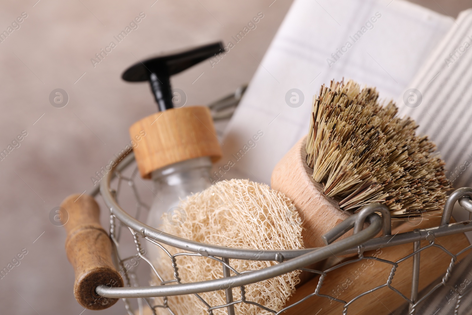 Photo of Metal basket with brush and cleaning tools on blurred background, closeup