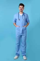 Young medical student in uniform on color background