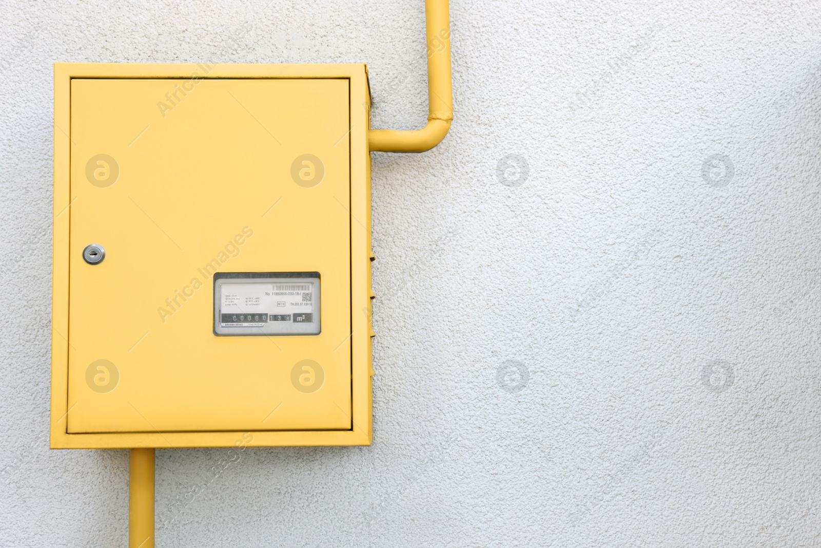 Photo of Gas meter box and pipes near grey wall outdoors. Space for text