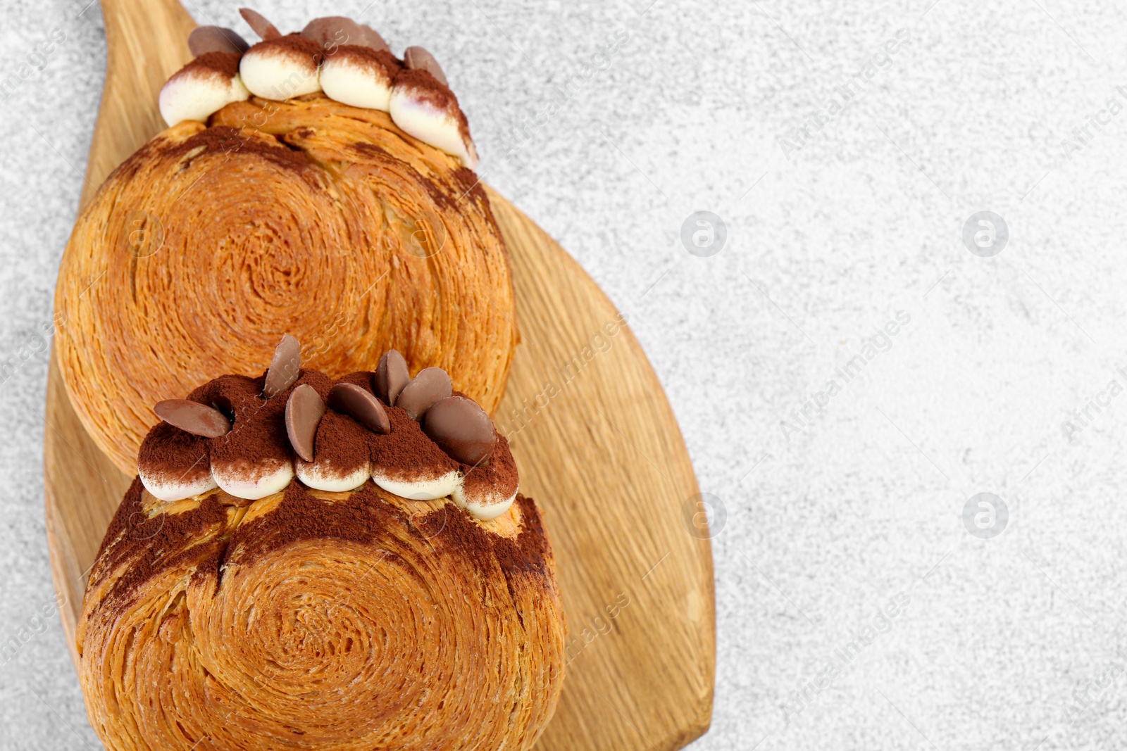 Photo of Tasty puff pastry. Supreme croissants with chocolate chips and cream on grey table, top view. Space for text