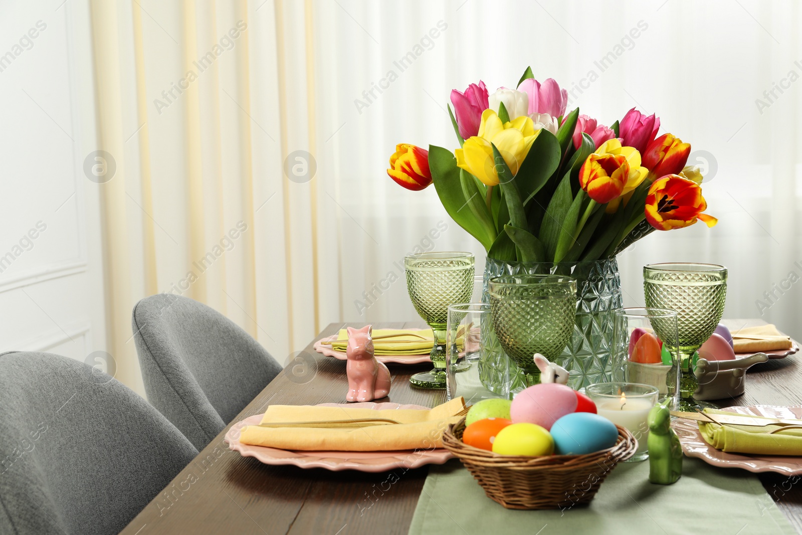 Photo of Easter celebration. Festive table setting with beautiful flowers and painted eggs