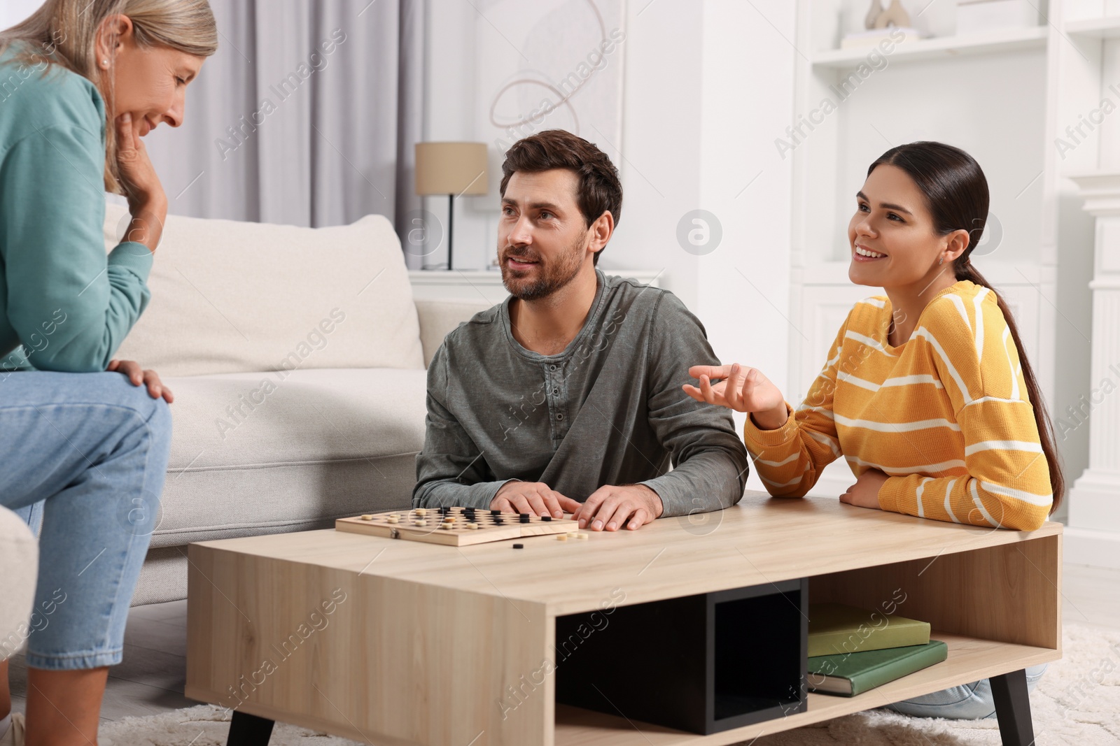 Photo of Family playing checkers at coffee table in room