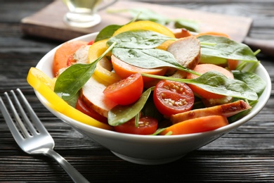 Delicious fresh chicken salad served on black wooden table, closeup