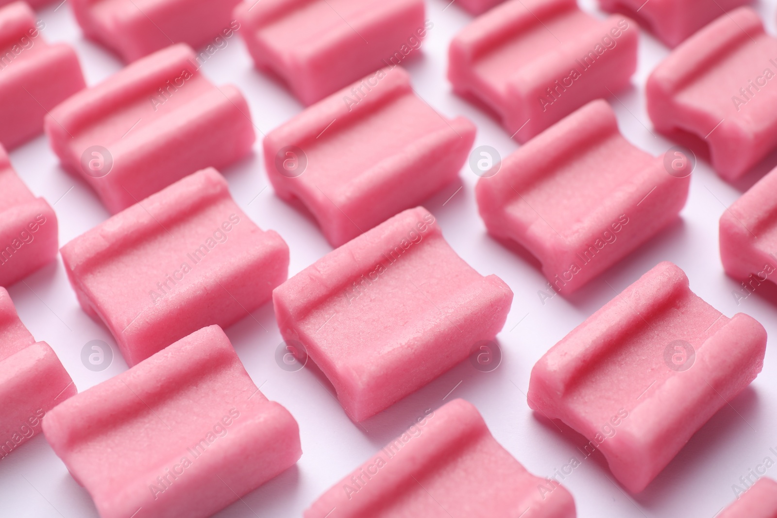 Photo of Tasty pink chewing gums on white background, closeup