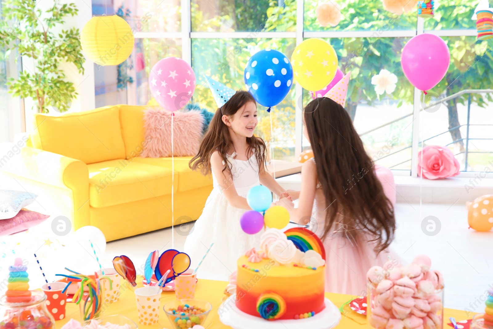 Photo of Cute girls playing together at birthday party indoors