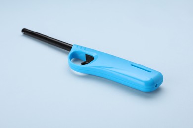Photo of One gas lighter on light blue background