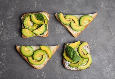 Tasty avocado toasts on grey table, flat lay