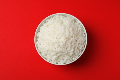 Photo of Bowl of tasty cooked rice on color background, top view