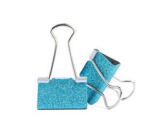 Photo of Turquoise binder clips on white background. Stationery item