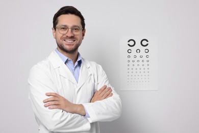 Photo of Ophthalmologist near vision test chart on white wall