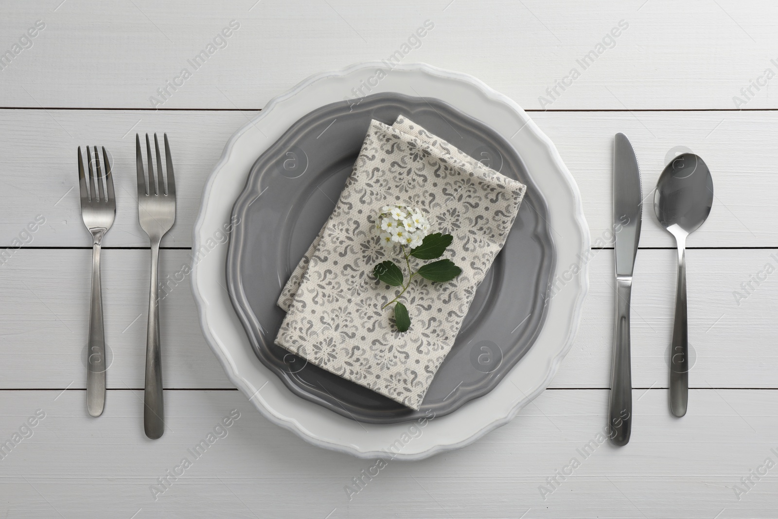 Photo of Stylish setting with cutlery and plates on white wooden table, flat lay