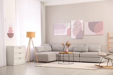 Photo of Stylish living room interior with big comfortable sofa and pictures