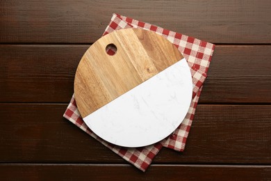 New cutting board and kitchen towel on wooden table, top view