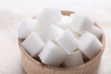 White sugar cubes in bowl on table, closeup