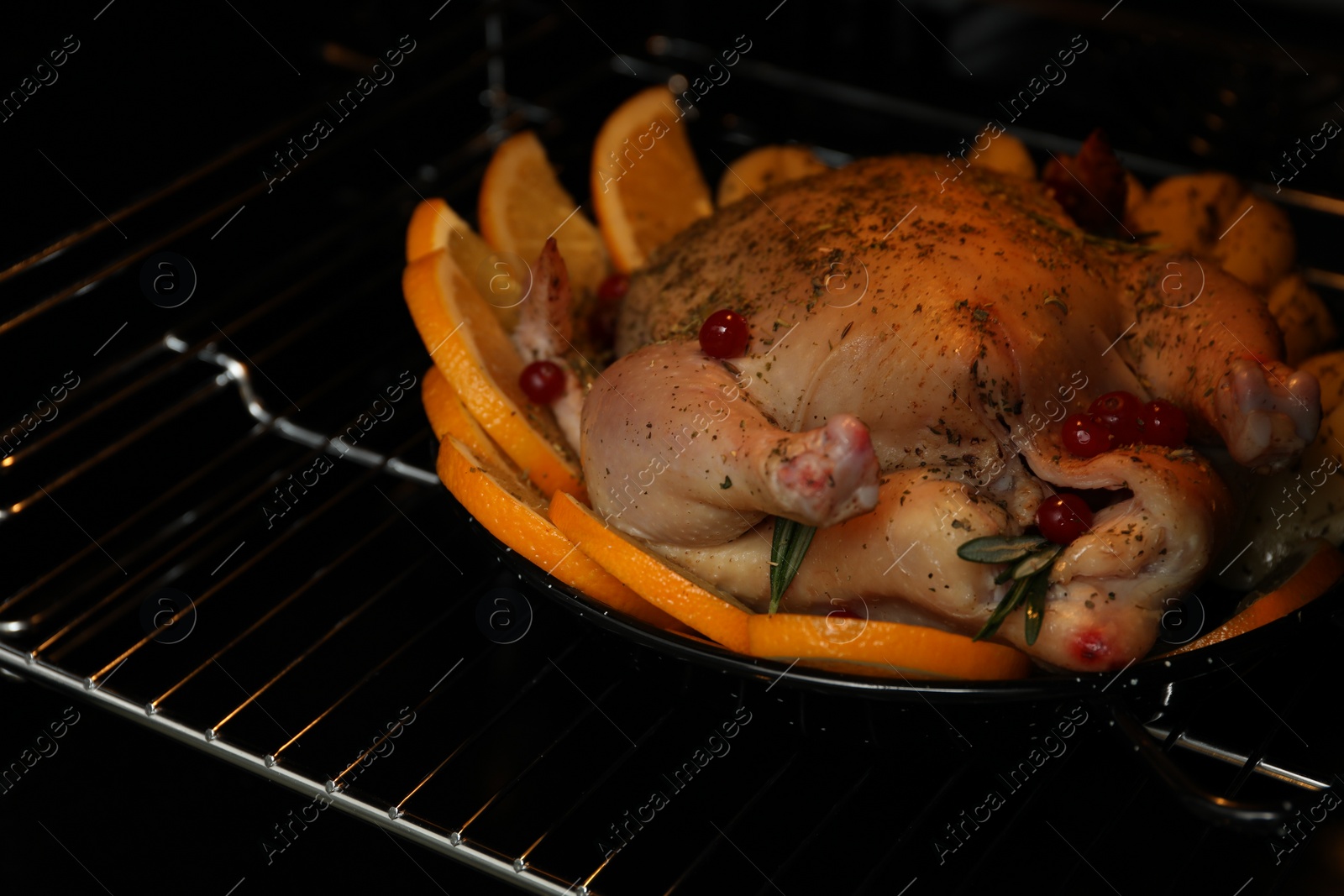 Photo of Chicken with orange slices baking in oven