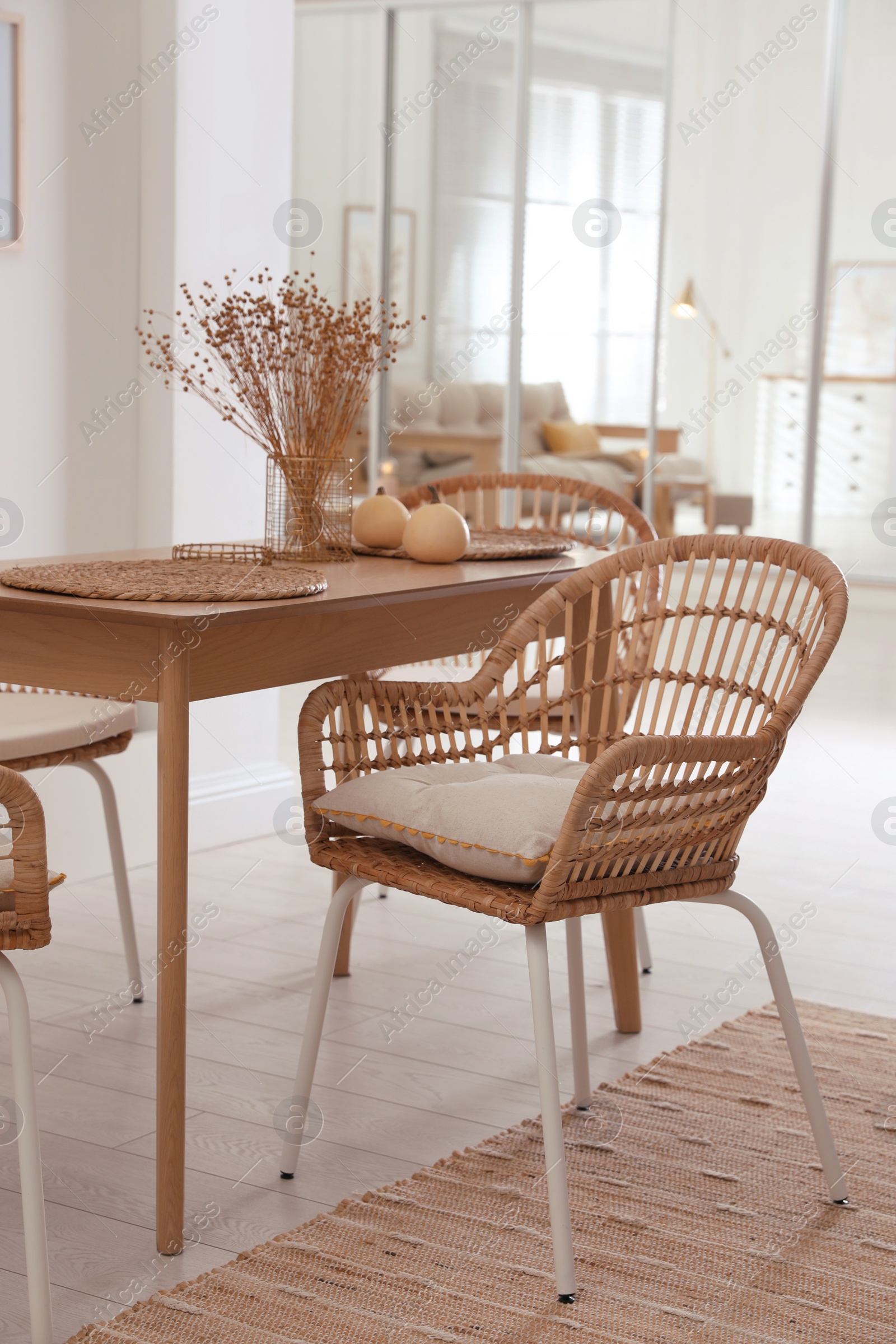 Photo of Dining room interior with wooden table and wicker chairs