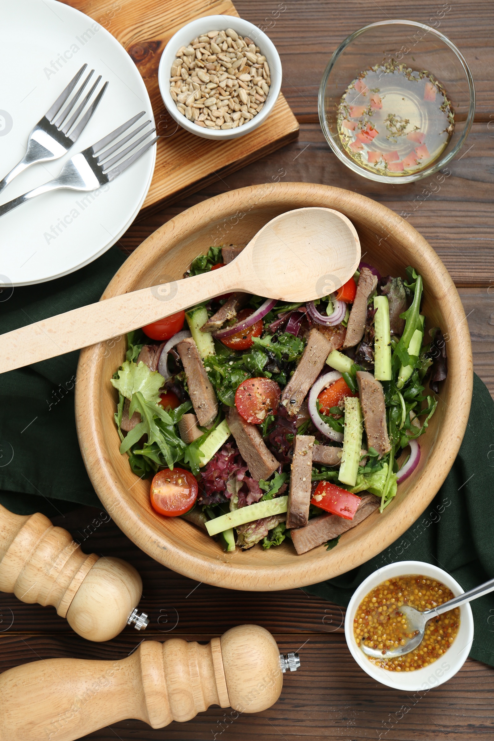 Photo of Delicious salad with beef tongue, vegetables and spoon served on wooden table, flat lay