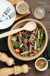 Delicious salad with beef tongue, vegetables and spoon served on wooden table, flat lay