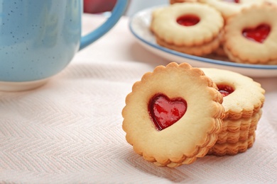 Photo of Traditional Christmas Linzer cookies with sweet jam on table