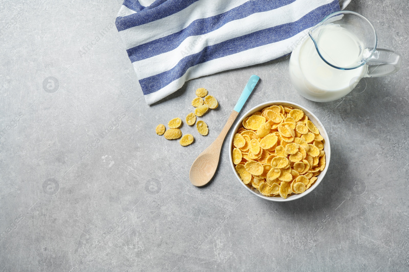 Photo of Tasty corn flakes on light grey table, flat lay. Space for text