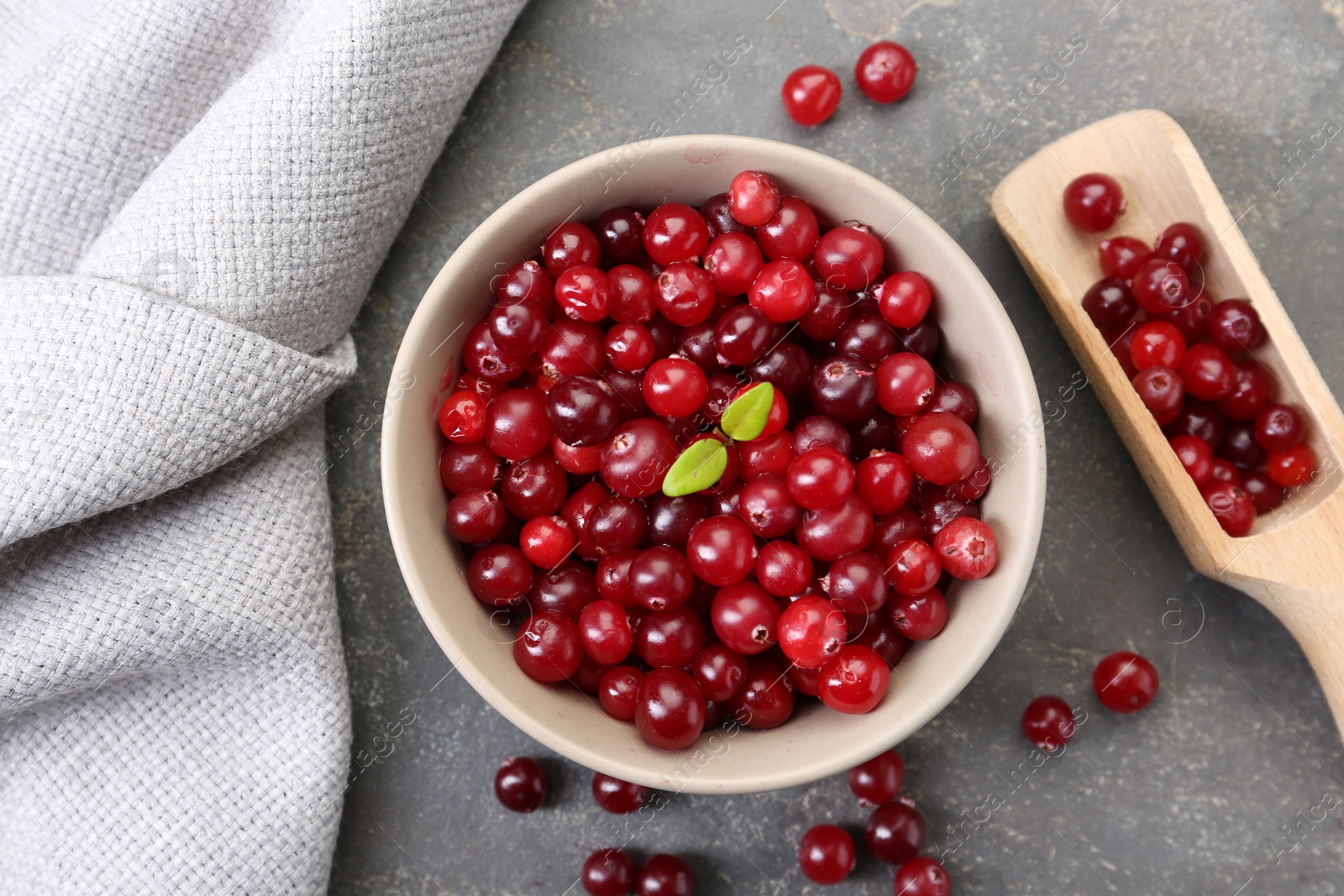 Photo of Fresh ripe cranberries in bowl and scoop on grey table, flat lay