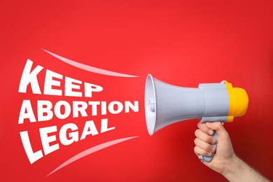 Image of Man with megaphone involved in reproductive rights protest, closeup. Slogan Keep Abortion Legal on red background