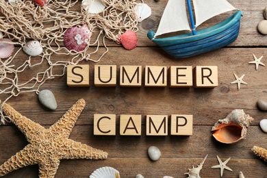 Photo of Flat lay composition with phrase SUMMER CAMP made of cubes on wooden background