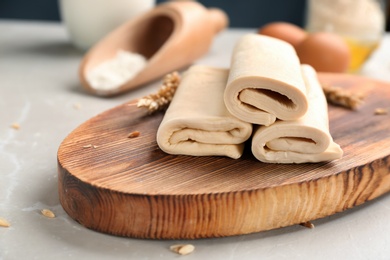 Photo of Wooden board with fresh dough on table. Puff pastry