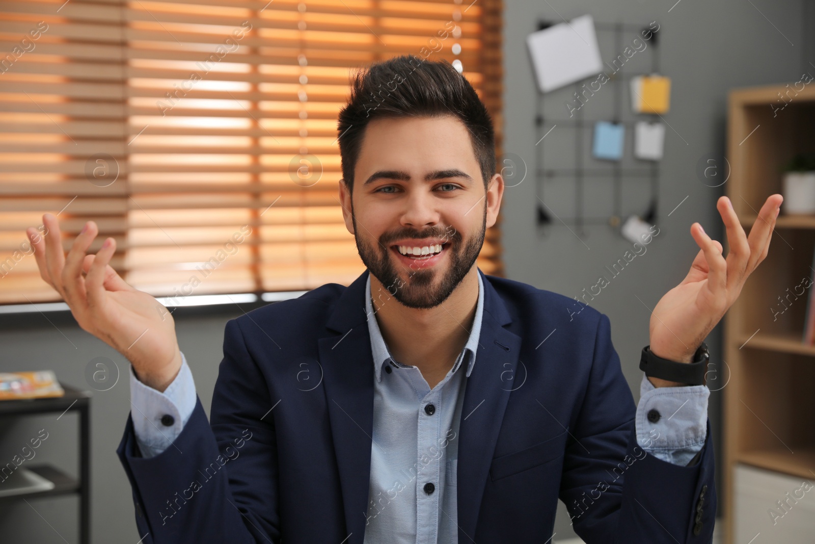 Photo of Happy young businessman conducting webinar in office