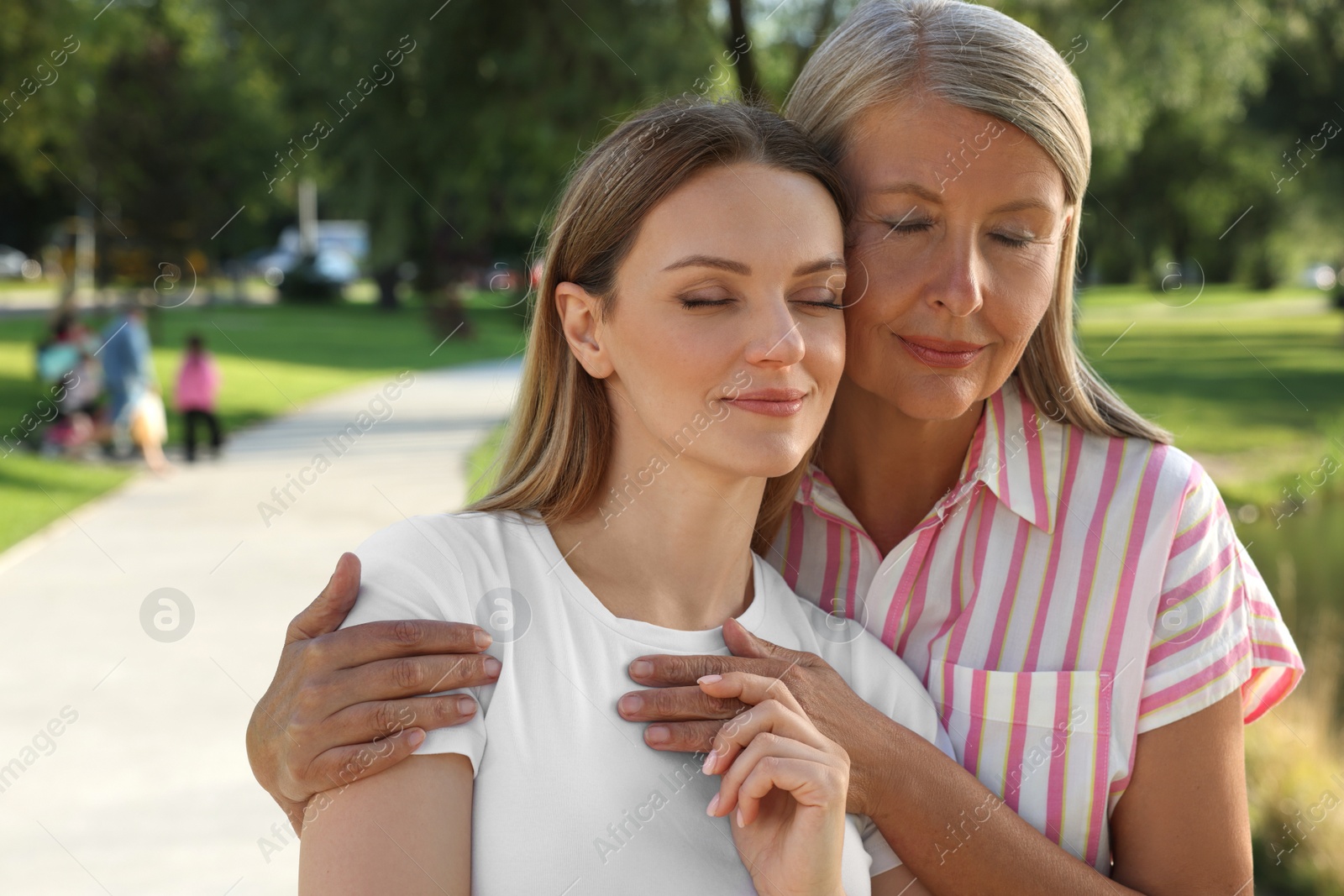 Photo of Family portrait of happy mother and daughter in park