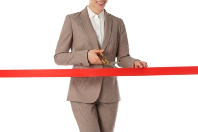 Photo of Woman in office suit cutting red ribbon isolated on white, closeup