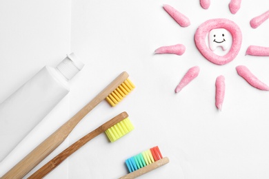 Photo of Composition small plastic tooth and oral care products on white background