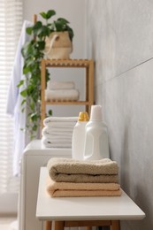 Photo of Soft towels, detergents and shelving unit indoors